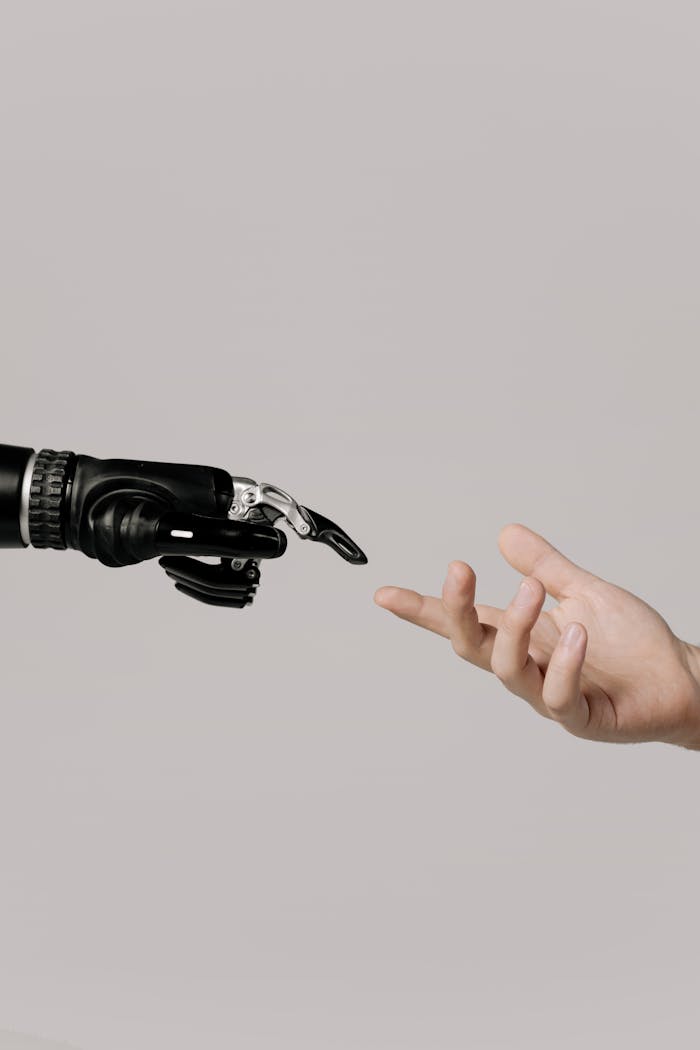digital A human hand reaching to touch a bionic prosthetic hand on a white background.